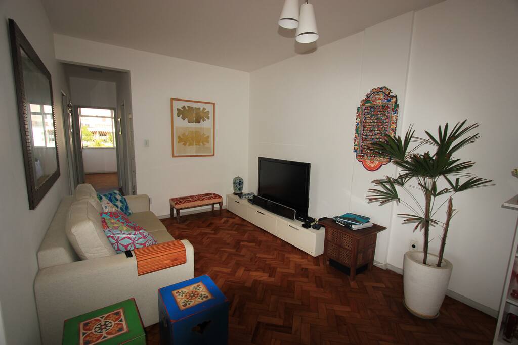 Sala de estar com sofá retrátil e TV a cabo.