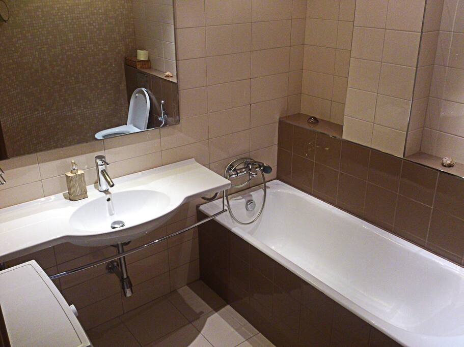Bathroom with bath, toilet and washing machine.