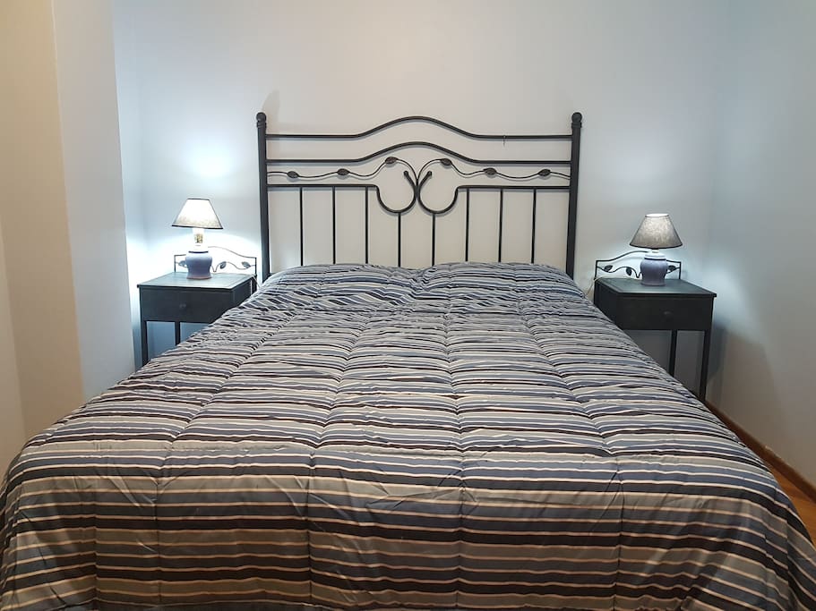Dormitorio con Cama matrimonial, mesas de luz individual, armario y teléfono