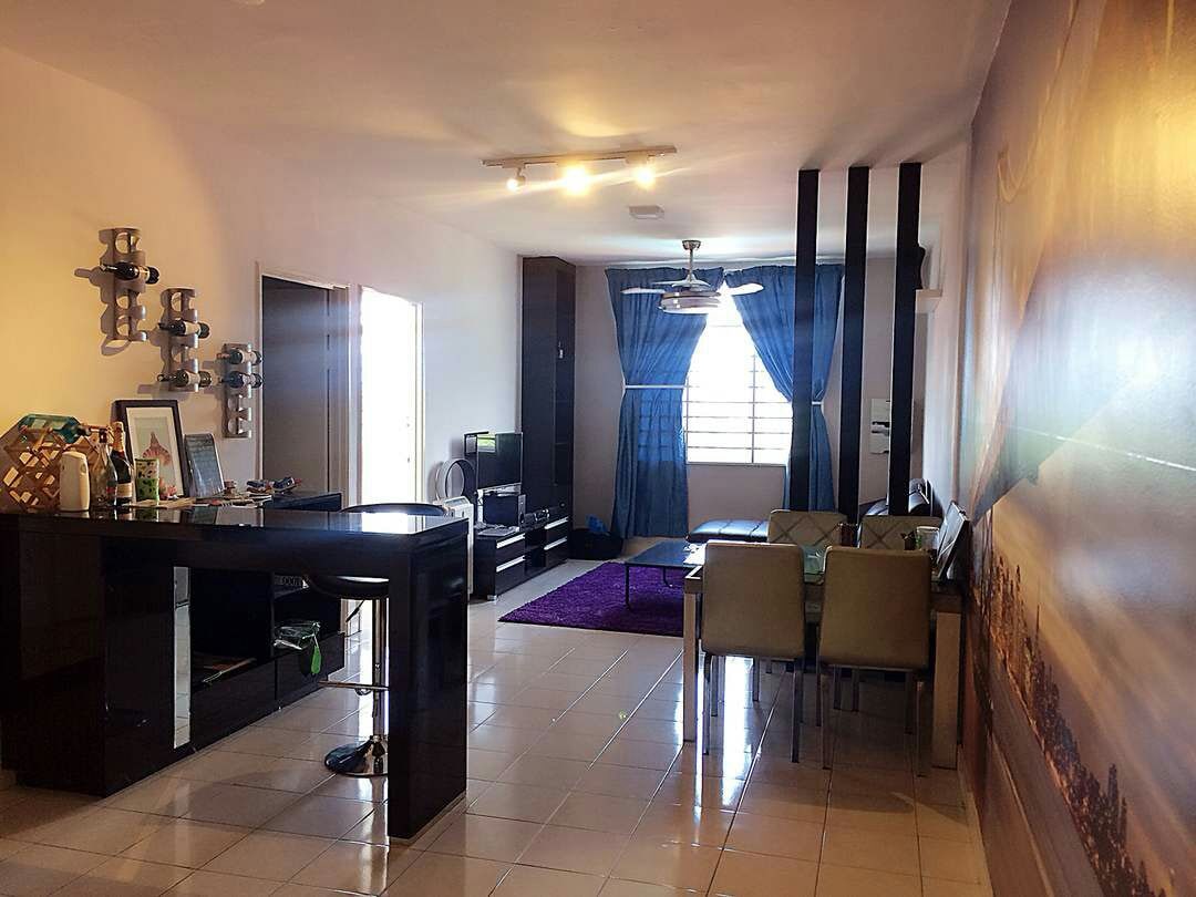 A spacious living area is illuminated by natural light streaming through large windows. A dining table with six chairs is positioned next to a cozy seating arrangement. A television stand is visible along with decorative wall fixtures, and a plush rug adds color to the floor.