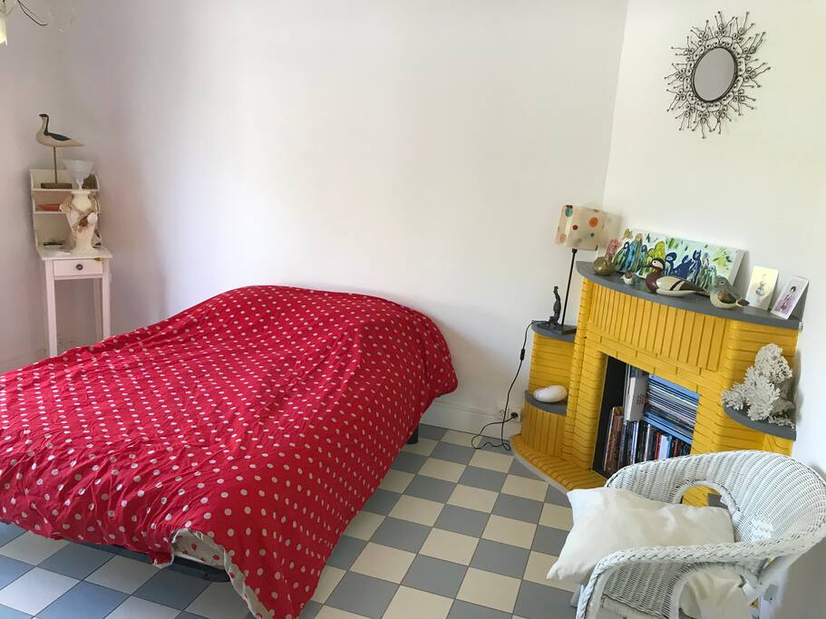 Chambre avec grande baie vitrée qui s'ouvre sur la terrasse en bois et son petit salon de jardin particulier