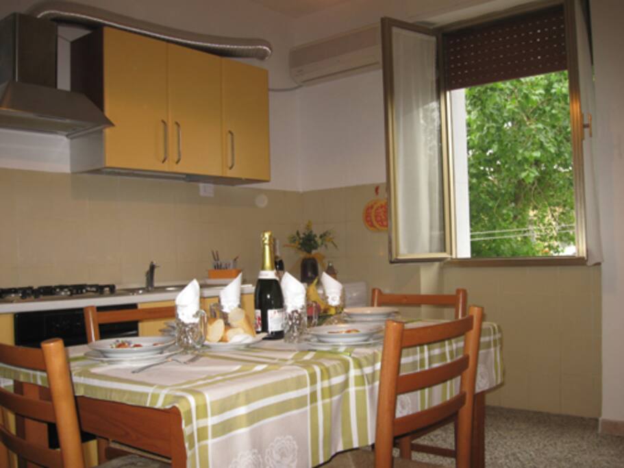 Cucina con vista in giardino condominiale, alberato