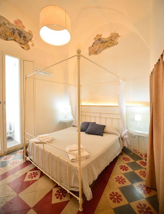 La stanza matrimoniale con affreschi e cementine originali - The master bedroom with frescos and vintage cement floor tiles