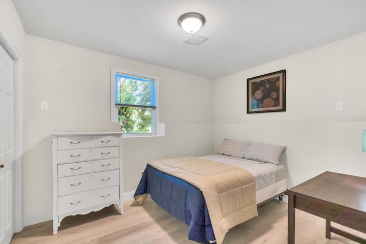 غرفة نوم في الطابق السفلي الثاني مع سرير كامل الحجم ومكتب ومكتب