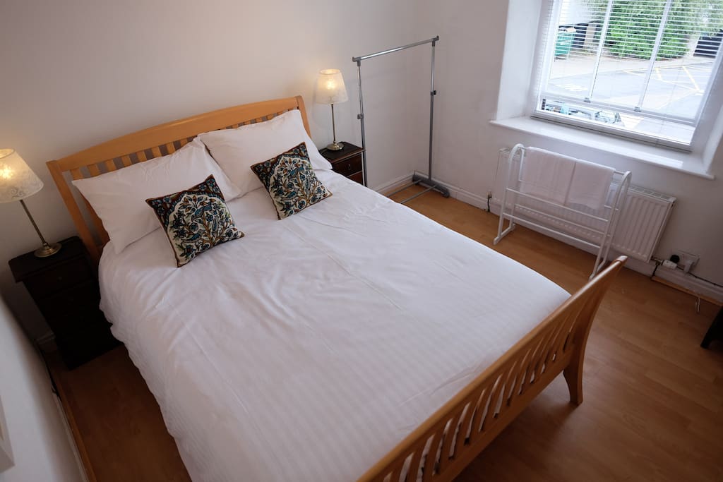 Bright bedroom with Kingsize bed, bedside cabinets with drawers, clothes rail and hangers, chest of drawers, mirror and Smart TV with Freeview channels, Netflix, Catch-up TV and other services