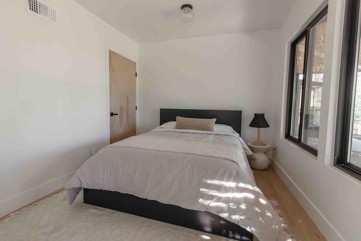 This is the 4th bedroom, uniquely situated with an attachment to the main house. To access this room, you'll step outside, it's on the right bottom corner and enter through a private entrance, ensuring exceptional privacy during your stay.