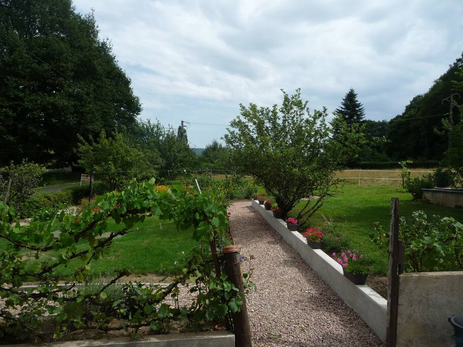 le jardin fleuri devant la maison, avec grand terrain pour s'amuser