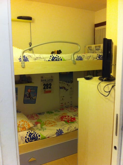 Cameretta con letto a castello armadio e televisione