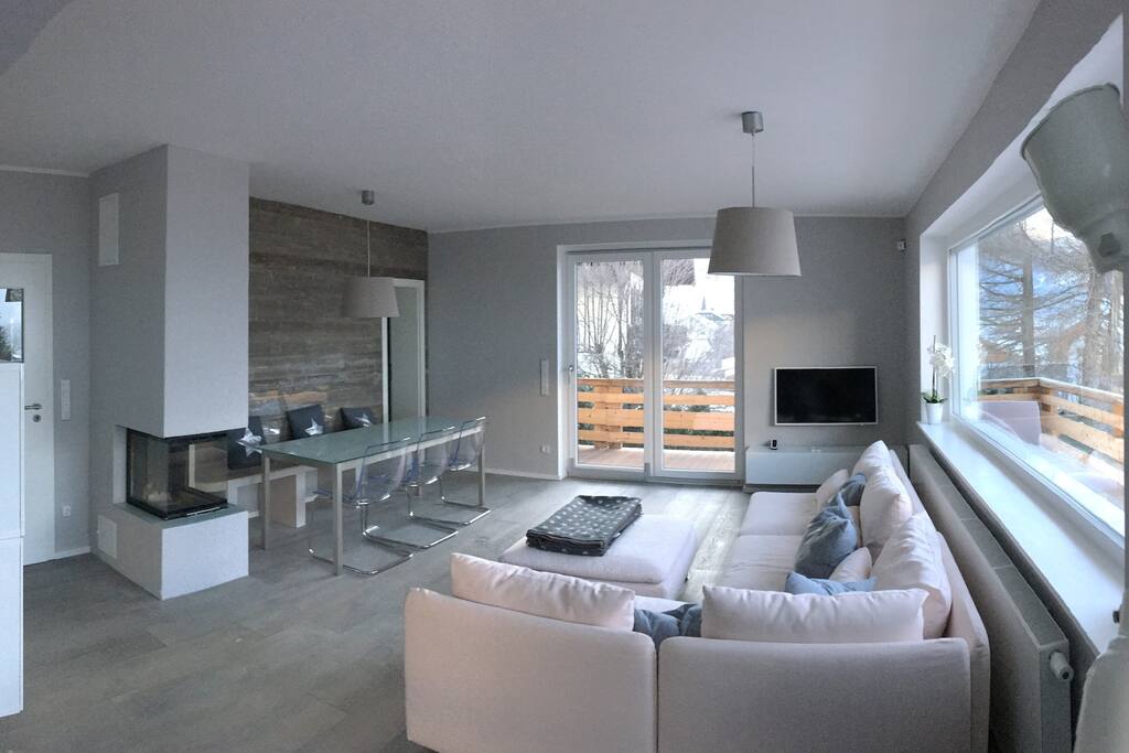 Wohnzimmer mit Kamin und Esstisch