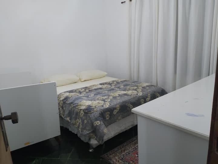 Dhomë me një krevat dopio dhe një komodinë .