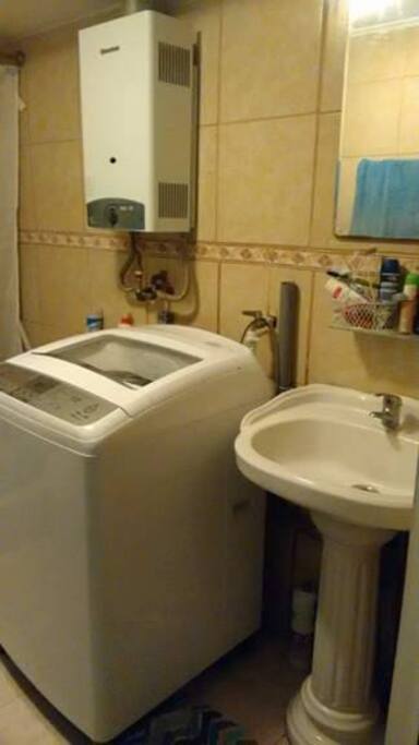 Washing machine offered in the bathroom/Baño con lavadora y agua caliente