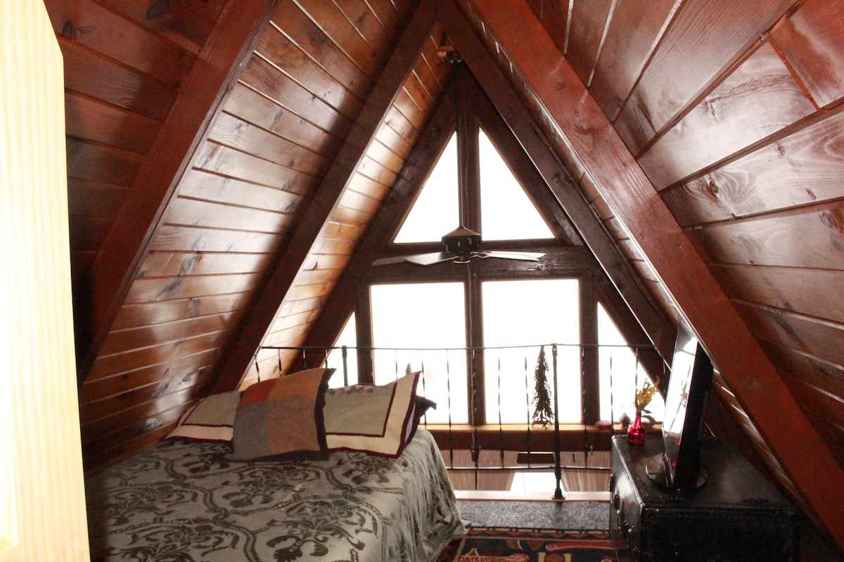 Tweepersoonsbed, flatscreen-tv - slaapkamer met uitzicht op Clam Lake. 
