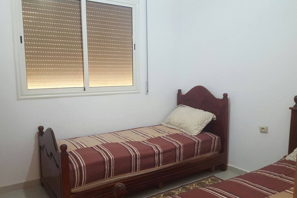 chambre équipée de 2 lits en bois