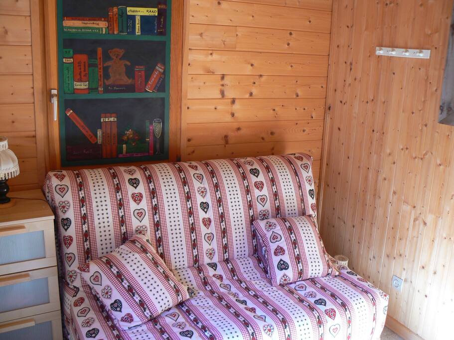 une chambre ou un coin lecture avec une porte fenêtre ouvrant sur les sapins