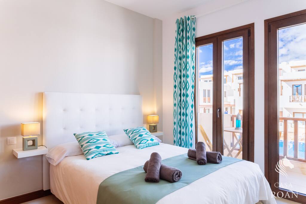 Dormitorio con terraza y vistas a piscina.