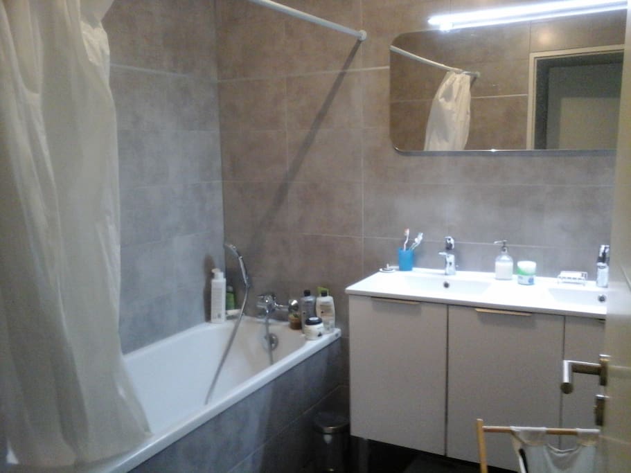salle de bain avec deux lavabos et une machine à laver.