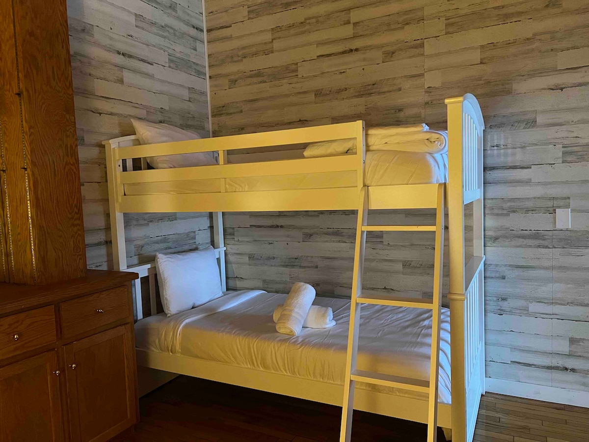 Chumba cha kulala cha watoto cha ghorofa ya 2 nje ya sebule ya ghorofa ya 2 na karibu na chumba kikuu cha ghorofa ya 2. Ina pacha juu ya kitanda cha ghorofa mbili.