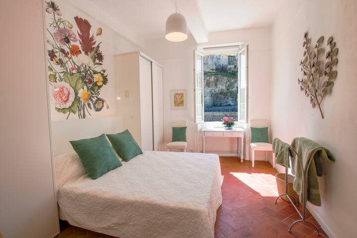 Спалня с двойно легло king size, монтирани шкафове и изглед към високия град и реката