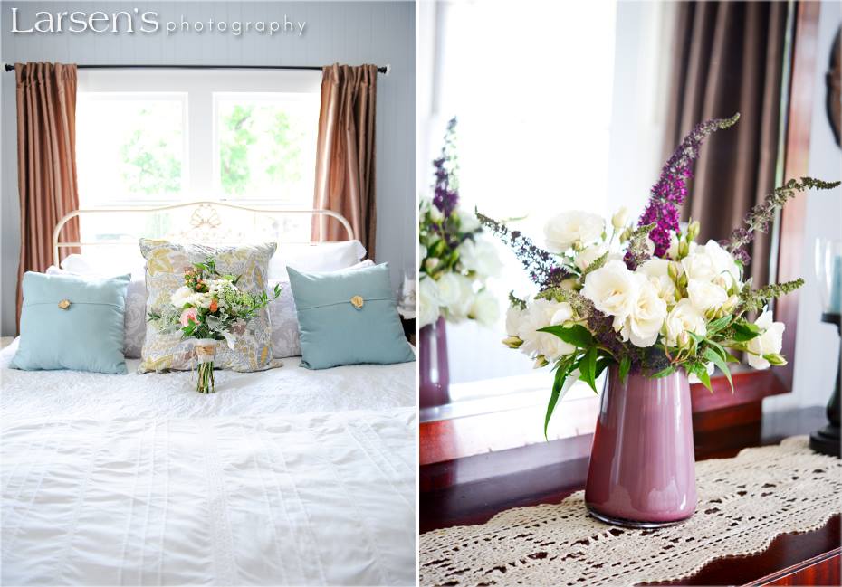 A spacious bed is dressed in elegantly arranged white bedding, complemented by decorative pillows in soft shades. A vase filled with fresh flowers is placed on a wooden dresser, adding a touch of color and natural beauty to the welcoming space.