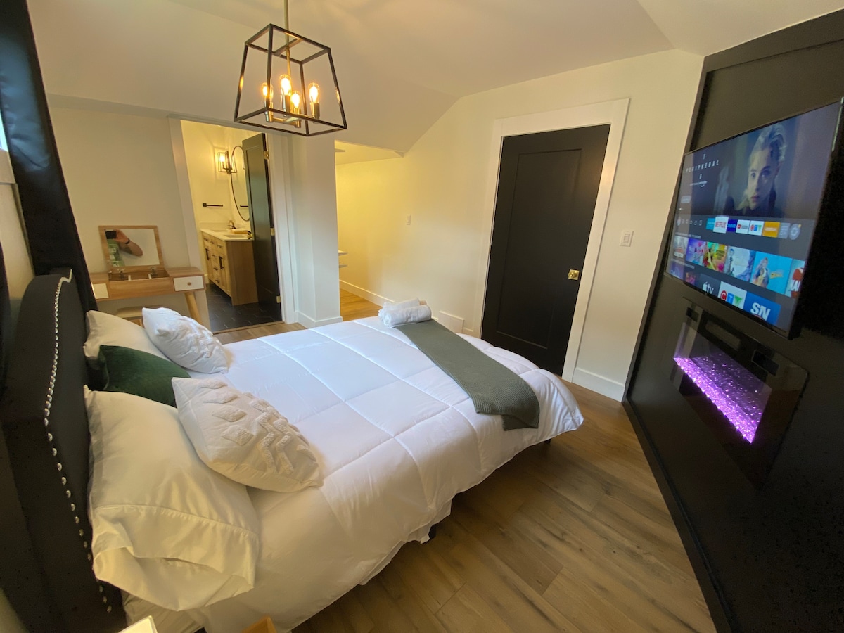 The master suit features a super comfy queen bed, 55" Netflix equipped Smart TV, electric fireplace, 4 piece en-suite bathroom and walk-in closet complete with an ironing board and iron. 