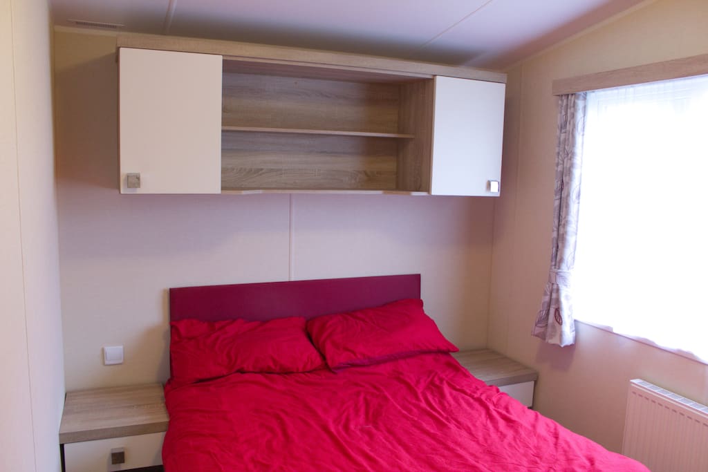 double bedroom with double wardrobe,bedside tables tv and ensuite toilet and sink