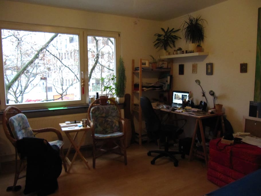 Blick zum Fenster mit Sitzecke und Schreibtisch