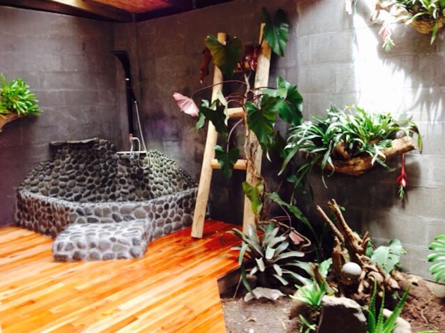 Lava rock bath with open roof and zen garden.