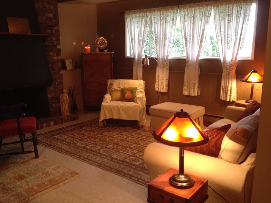 Living room with working fireplace, silk rugs and plenty of natural light.