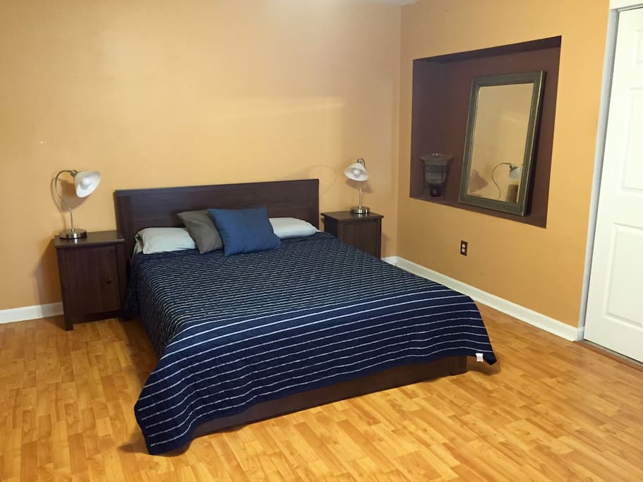 The master bedroom is three steps below the living room & features a queen bed, two bedside tables, two closets, a dresser & an attached bathroom