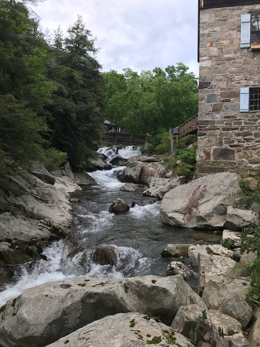 Looking upstream at the Millhouse with the footbridge and cozy screen house in the background.