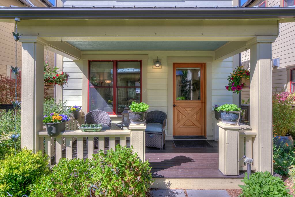 Cottage porch with comfortable chairs and pullout ottomans made to relax on.