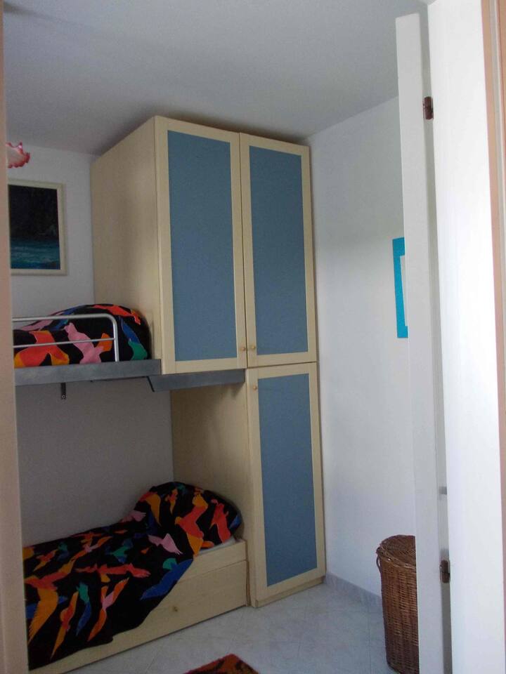 Chumba kidogo cha kulala chenye vitanda vitatu vya mtu mmoja