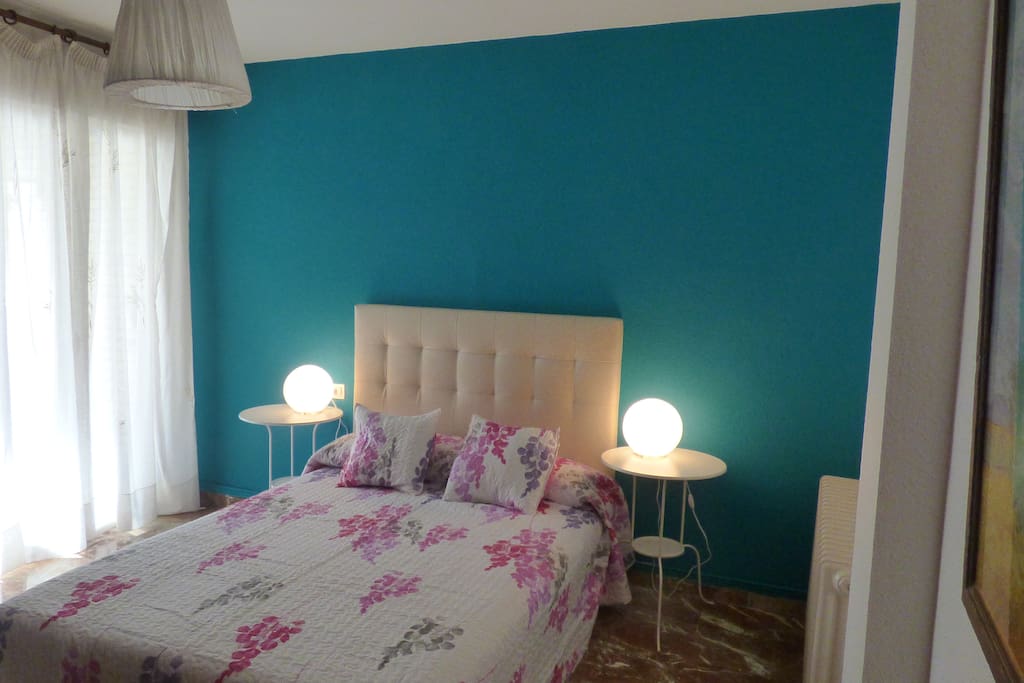Dormitorio con cama doble y terraza.
