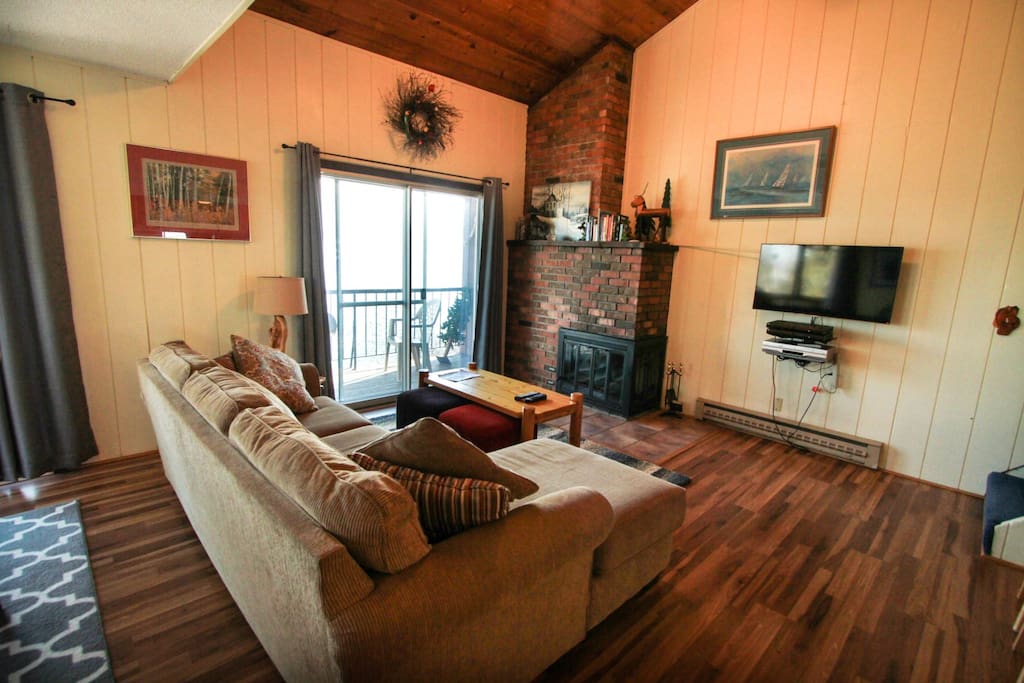 The living room features a brick fireplace and flat screen TV.