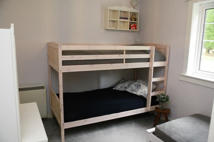 חדר שינה 3, הממוקם בסמוך לקוטג', עם מיטת קומתיים ומיטת יחיד.