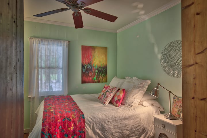 Ceiling fan over queen bed and bedside reading lamp.