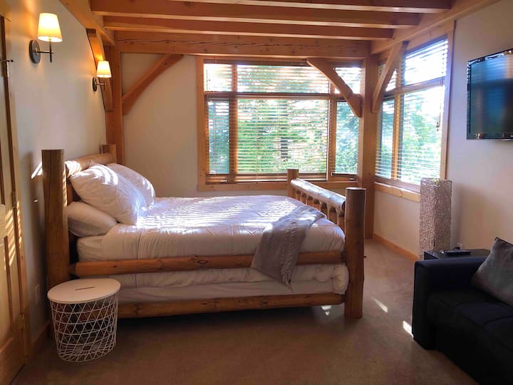 Master bedroom with king-sized log frame bed, tv, and sofa bed. Private en suite with jacuzzi tub. 