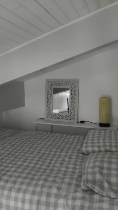 Lit en 120 cm situé sur une mezzanine, toit rampant. Accès par une échelle meunière.