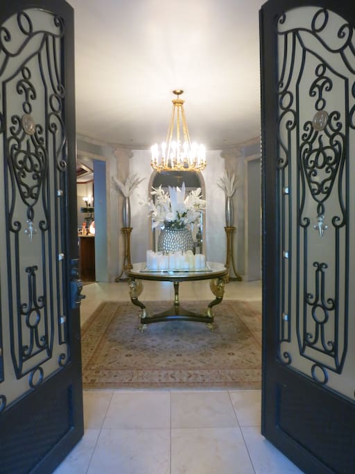Custom wrought iron double doors open to the foyer.