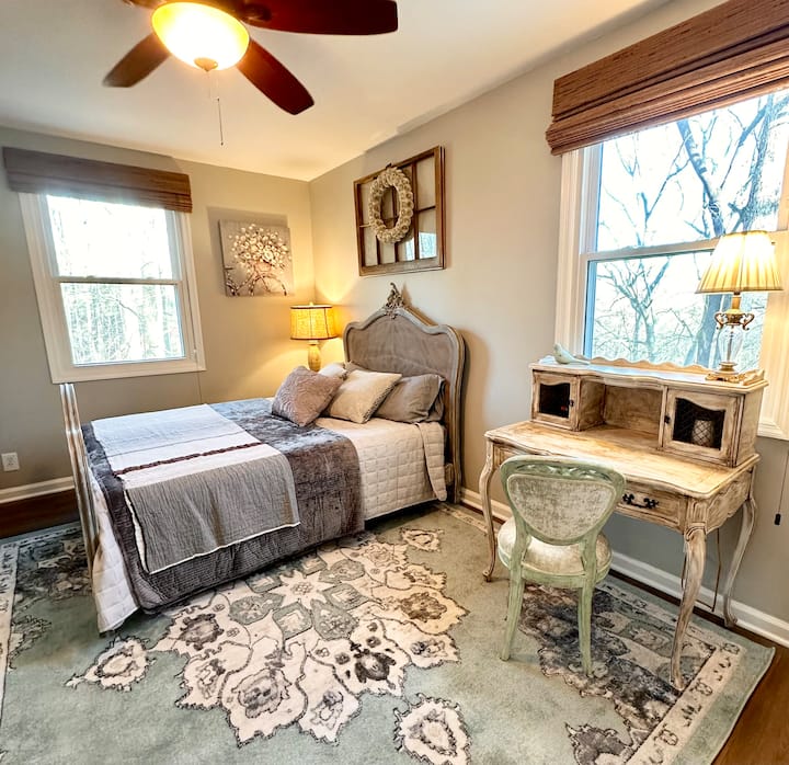 This room includes a darling double bed, desk, and chair in a reading nook. 