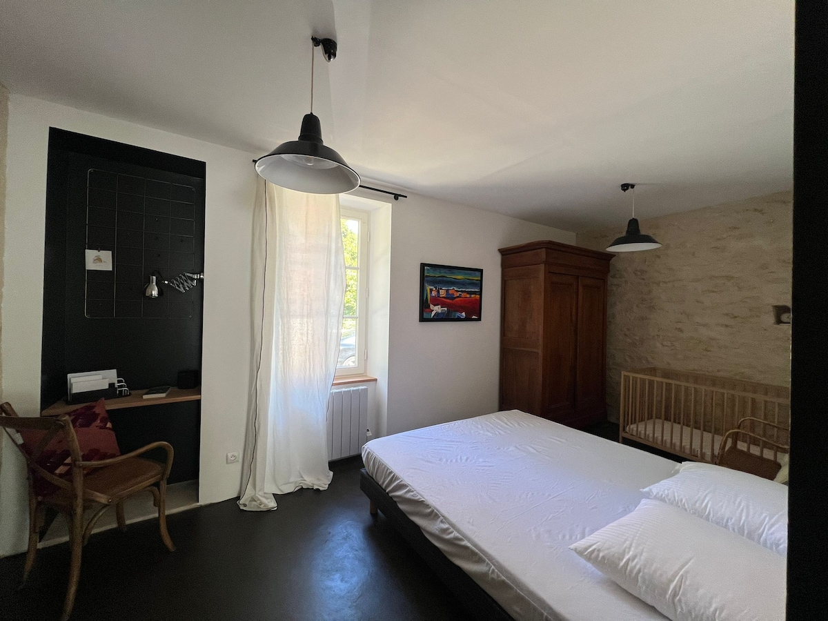 1号卧室（一楼，厨房后面）。 卧室配有160x200张床、木质婴儿床、橱柜和书桌区域。