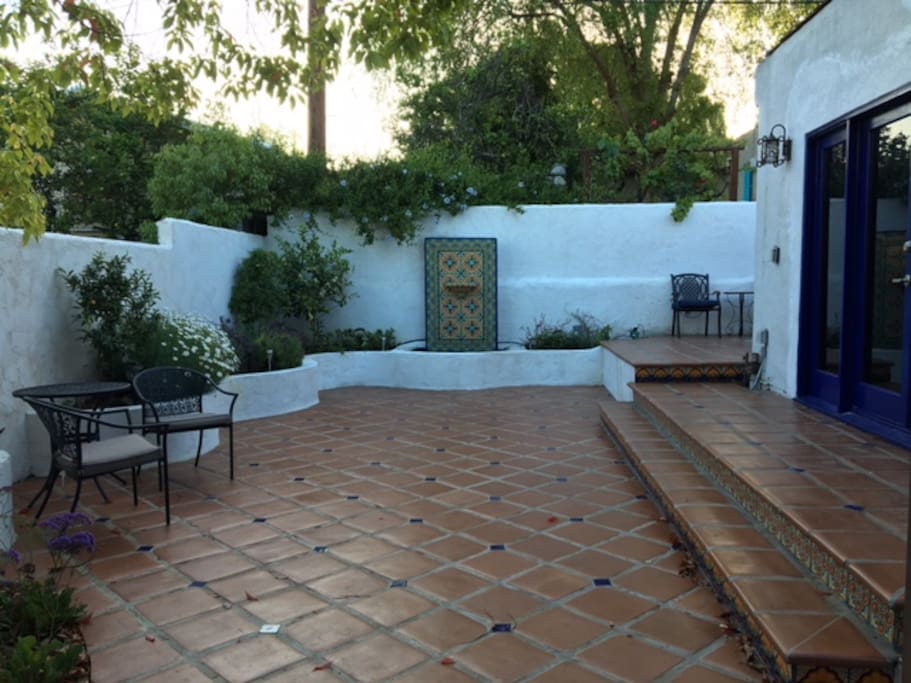 Patio with fountain, adjacent tables, seating and barbecue