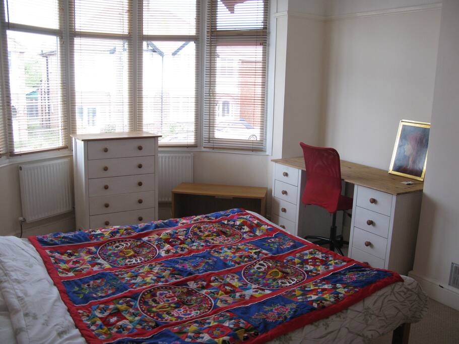 The double bedroom, with wooden blinds, desk, chest of drawers and a good sized wardrobe