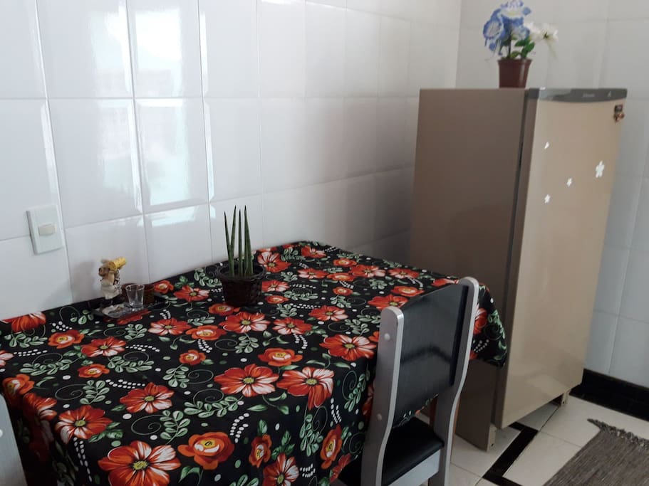 Cozinha com mesa, cadeiras e geladeira