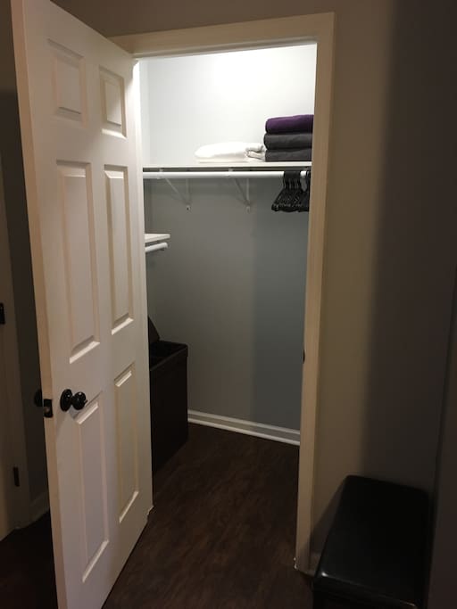 CLOSET: full walk in closet with fresh towels, hangers, and clothes hamper
