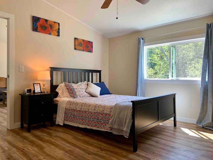 Master Bedroom - queen size bed with quilt and extra blanket, nightstand, and alarm clock.