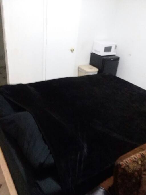 queen size bed, microwave and refrigerator