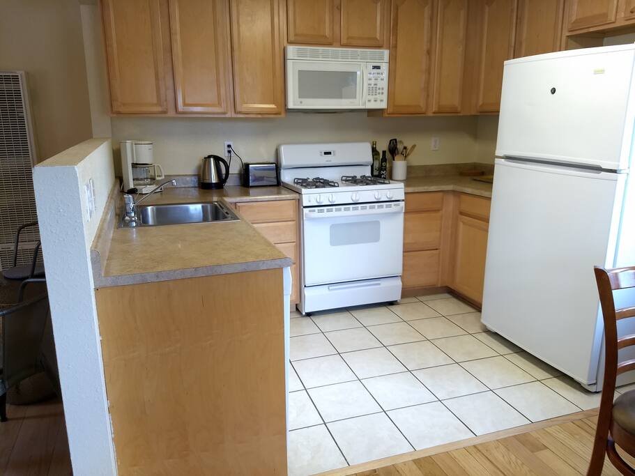 Full kitchen has a gas range, dishwasher, microwave, coffee maker, electric kettle, toaster and a blender