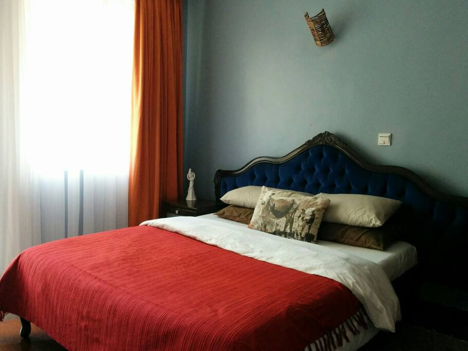 The main bedroom is situated near a large window and balcony area.