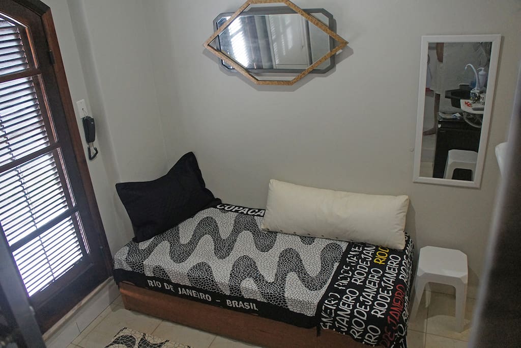 A cama inferior, estilo "gaveta", fechada. esquerda, a porta dupla de acesso ao terraço.